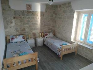 a bedroom with two beds and two windows at Yellow submarine in Olib