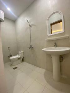 a bathroom with a sink and a toilet and a mirror at قصر أباهي للوحدات السكنية المفروشة in Al Nairyah
