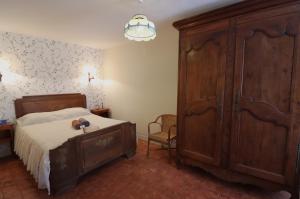 a bedroom with a bed and a large wooden cabinet at Location de Chambres Bienvenue chez Mémé in Treigny