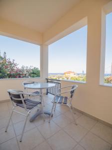 a table and two chairs on a balcony with windows at Apartments Hotel & Studios, Xifoupolis in Monemvasia