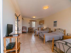 a room with two beds and a television in it at Apartments Hotel & Studios, Xifoupolis in Monemvasia