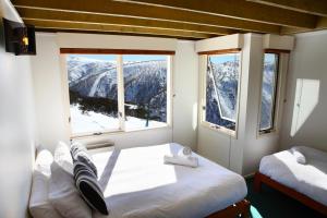 a bedroom with two beds and a window with mountains at Gotcha in Mount Hotham