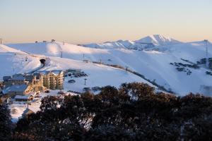 a resort in the snow with mountains in the background at Gotcha in Mount Hotham