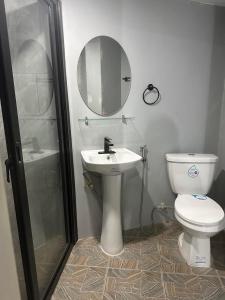 a bathroom with a toilet and a sink and a mirror at Trail Bedz Homestay in Baguio +100 photos