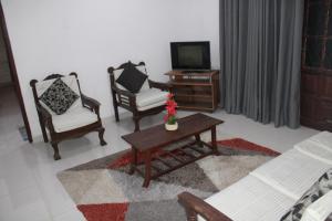 a living room with two chairs and a table and a tv at Hills Kandy Apartment in Kandy