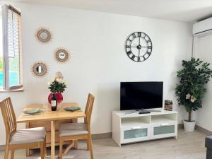 un comedor con una mesa y un reloj en la pared en Séjour magique proche aéroport CDG Astérix Disney et Paris Maison toutes commodités, terrasse, WIFI, CLIM, lave vaisselle, en Saint-Mard