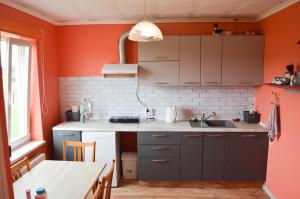 a kitchen with orange walls and a sink and a table at Cherry Apartment in Madliena