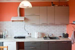 a kitchen with orange walls and a sink and a lamp at Cherry Apartment in Madliena +16 photos