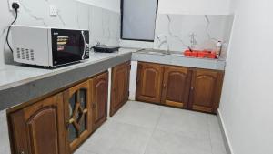 a kitchen with a microwave and a sink at Hills Kandy Apartment in Kandy