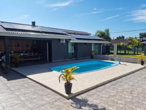 a swimming pool in the backyard of a house at Casa Alto Padrão Perto da Praia C/ Piscina Grande in Guaratuba