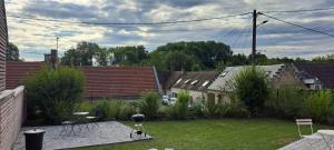 a backyard with a yard with a grill and some houses at La maison d'à côté Chambre 2 in Cuise-la-Motte