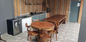 a kitchen with a wooden table and a stove at Casa Alto Padrão Perto da Praia C/ Piscina Grande in Guaratuba