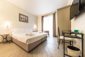 a hotel room with a bed and a flat screen tv at Hotel San Pietro Palace in Finale Ligure