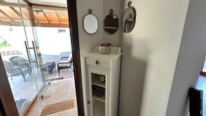 a small white cabinet with two mirrors on the wall at villamonda in Kızilbahçe