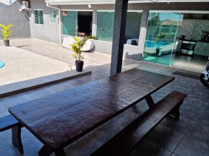 a wooden table and bench on a patio at Casa Alto Padrão Perto da Praia C/ Piscina Grande in Guaratuba +18 photos