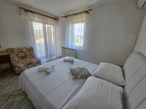 a bedroom with a large white bed and a couch at Rooms Tanja Lovran in Lovran