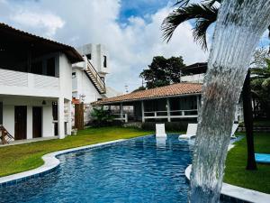una fontana di fronte a una casa di Casa de Temporada cinco quartos - Garça Torta em Maceió - Vista Mar a Maceió