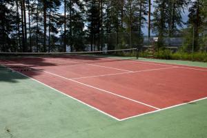 a tennis court with a net on top of it at Hideaway Glamping in Muurame