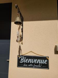 a sign hanging on a wall with a bell at Le QG chez Flo et David in Saint-Julien-Molin-Molette