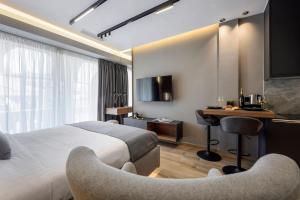 a hotel room with a bed and a desk at Aristotelian Virtues - Agapi in Thessaloniki