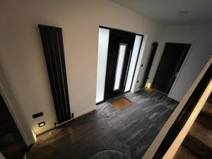 an empty room with black doors and wooden floors at Art Deco 52 in Truro