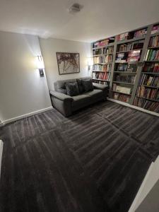 a living room with a couch and book shelves at Art Deco 52 in Truro