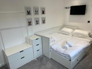 a white bedroom with a bed and a tv at Art Deco 52 in Truro +16 photos