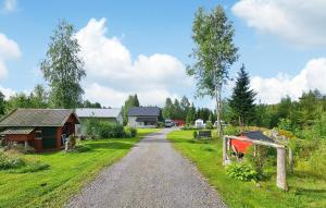 a gravel road leading to a house and a barn at 2 Bedroom Stunning Home In Skotterud in Magnor