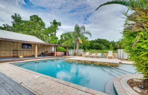 a swimming pool with chairs and a house at Spacious Micanopy Farmhouse with Luxurious Pool! in Micanopy