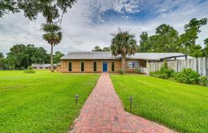 a house with a brick driveway in front of a yard at Spacious Micanopy Farmhouse with Luxurious Pool! in Micanopy