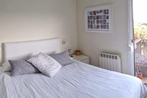 a bedroom with a white bed with pillows and a window at Gavá Vila Blanxe in Gavà +21 photos