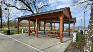 a picnic shelter with benches in a park at Carpe Diem Lakeside Suite Apartments in Szczecin