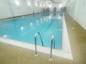 una grande piscina coperta con acqua blu di Bay Cottage a Filey