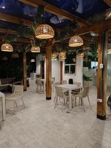 a dining room with tables and chairs and chandeliers at Hotel Aqua House in Tubará