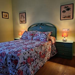 a bedroom with a bed and two night stands with lamps at Casa Buenavista Vut in Revenga