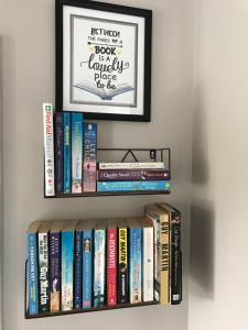 a shelf of books with a framed picture on it at Cosy Nook Cottage Kesh in Kesh