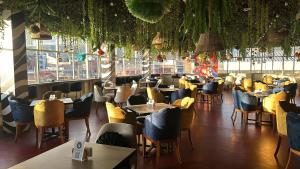 a restaurant with tables and chairs and a room with windows at Hotel Casahuanca Olimpico in Huancayo