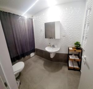 a bathroom with a white toilet and a sink at Happy Pipera 3 Luxury Rooms in Voluntari +5 photos