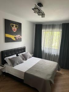 a bedroom with a bed with a picture of a woman with sunglasses at Happy Pipera 3 Luxury Rooms in Voluntari