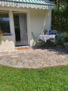 a patio with a table and chairs in front of a house at Bungalov in Gozd Martuljek