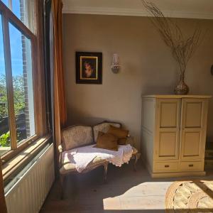 a room with a chair next to a window at Appartement B&B Boskoop in Boskoop