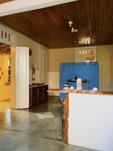 a kitchen with a counter in the middle of a room at Hostel Casarão in Viçosa
