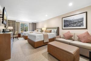 a hotel room with two beds and a couch at The Lodge at Jackson Hole in Jackson