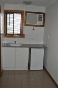 a kitchen with a sink and a microwave at Keith Motor Inn in Keith