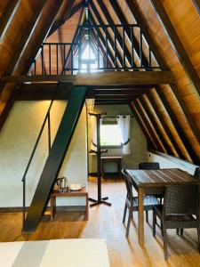 a loft with a table and a staircase at Cannelle Hill Cabanas in Deniyaya +35 photos