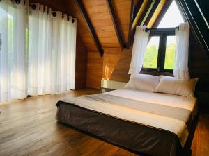 a bedroom with a large bed with a window at Cannelle Hill Cabanas in Deniyaya