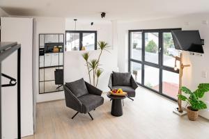 a living room with two chairs and a tv at DOM Inn in Mörfelden-Walldorf