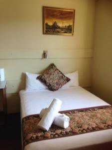 Una habitación de hotel con una cama con toallas. en Hotel Beach House Nambour en Nambour