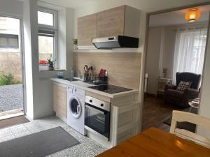 a kitchen with a washer and a sink and a stove at Petite maison dans le Morvan in Luzy +8 photos
