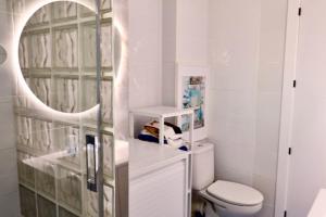a white bathroom with a toilet and a mirror at Altea Sound of the Sea in Altea +16 photos